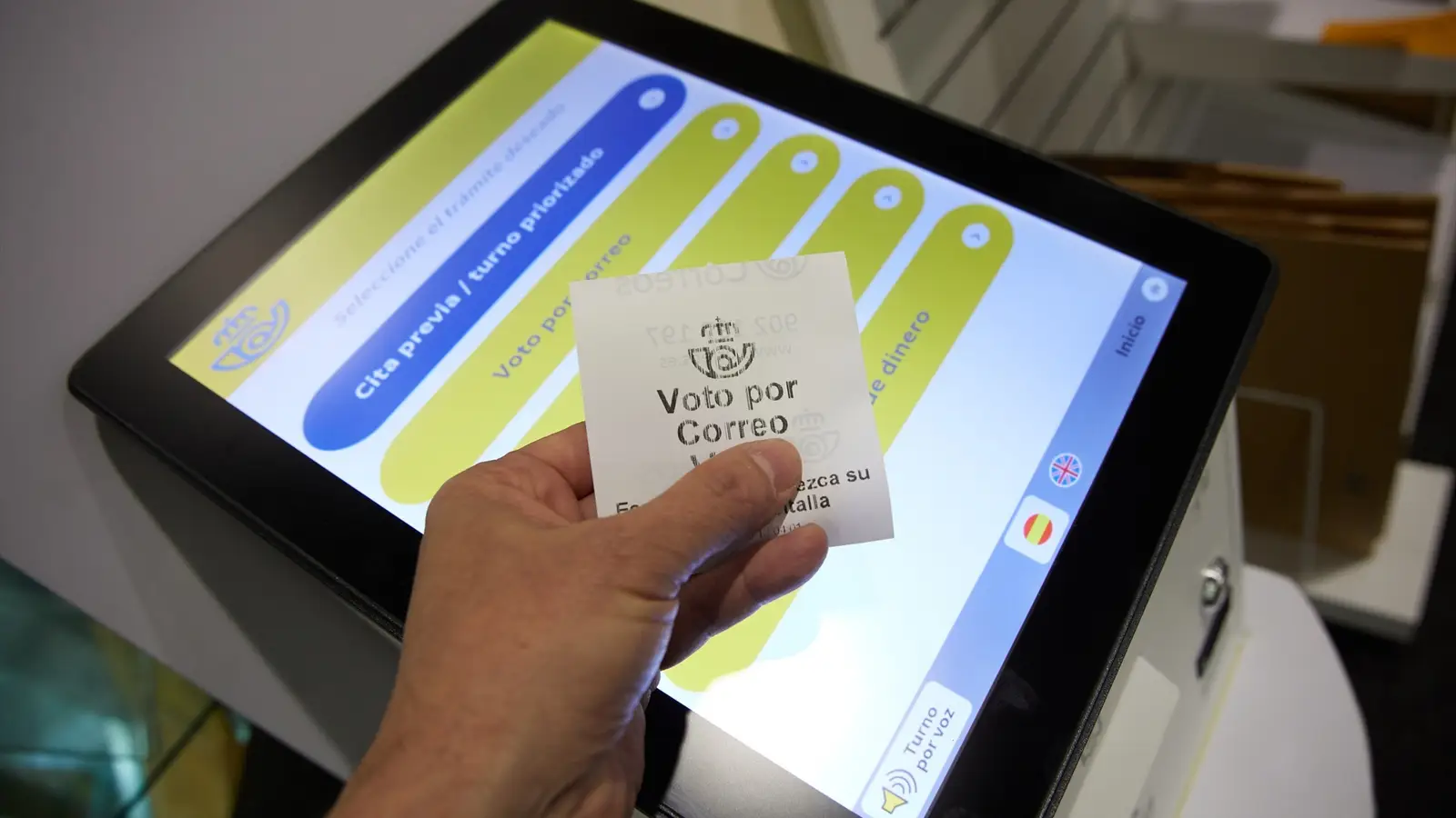 Una persona con un ticket de voto por correo en la oficina de Correos de Cibeles | Jesús Hellín / Europa Press