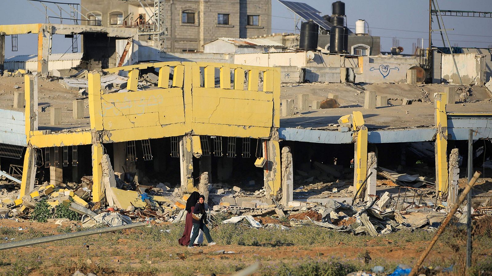 Palestinos junto a un edificio destruido en el campo de refugiados de al-Maghazi, en el centro de la Franja de Gaza EYAD BABA / AFP