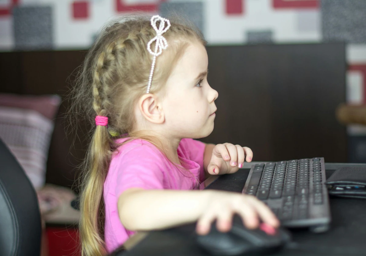 Una niña frente a un ordenador UNSPLASH