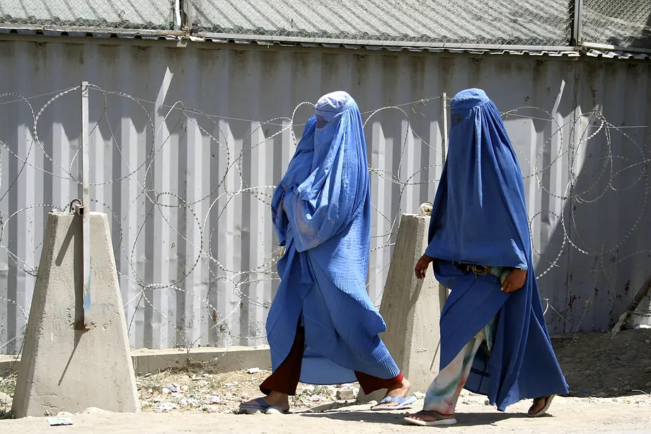 Dos mujeres afganas vestidas con el tradicional burka caminan frente a la embajada de Reino Unido en Kabul.Amador Guallar | Hans LucasEM