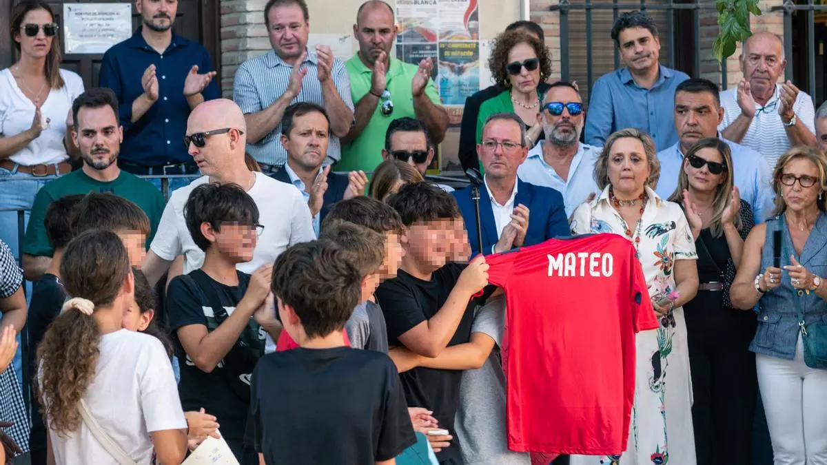 Amigos de Mateo muestran una camiseta con su nombre, durante el minuto de silencio por su asesinato, en la puerta del Ayuntamiento de Mocejón. EUROPA PRESS