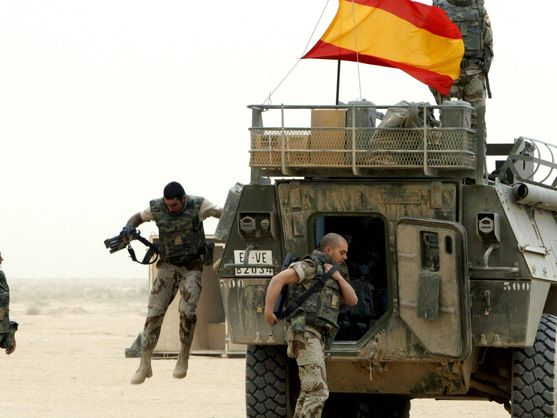 Soldados españoles saltan de su vehículo personal blindado en una base militar estadounidense cerca de la ciudad iraquí de Najaf, en abril de 2004. (Reuters)