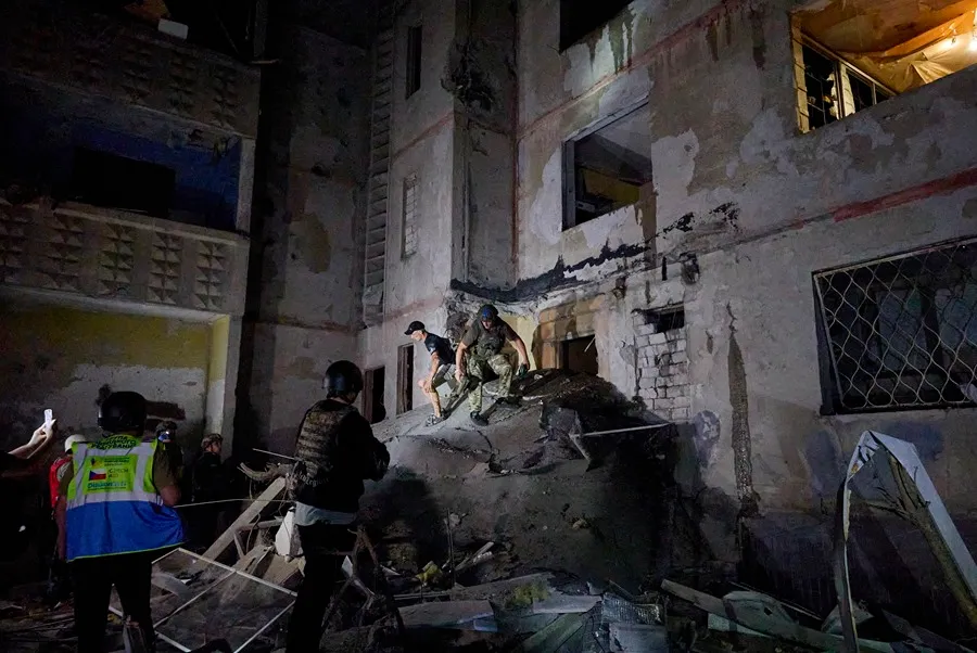 Los rescatistas ucranianos evacuan a la población local del lugar del bombardeo nocturno contra un edificio residencial de varios pisos en Kharkiv, al noreste de Ucrania. EFE/EPA/Sergey Kozlov