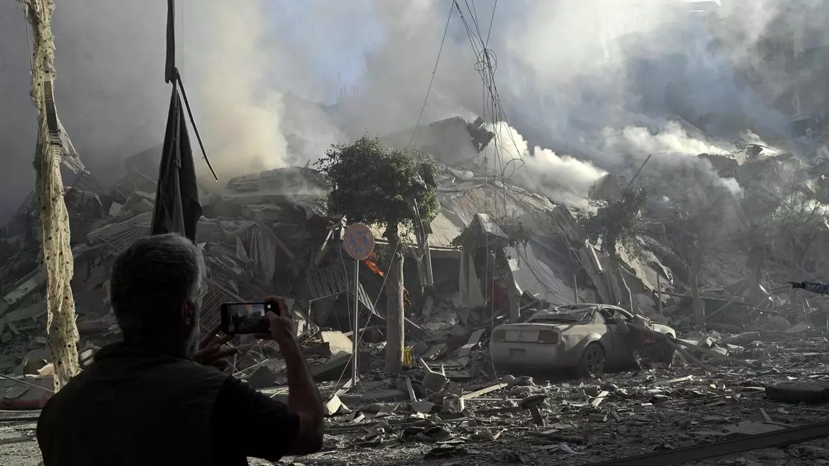 Un hombre fotografía un edificio humeante después de un ataque aéreo israelí sobre el barrio de Dahieh, uno de los bastiones de Hizbulá, en Beirut (El Líbano) este jueves EFE/ Wael Hamzeh