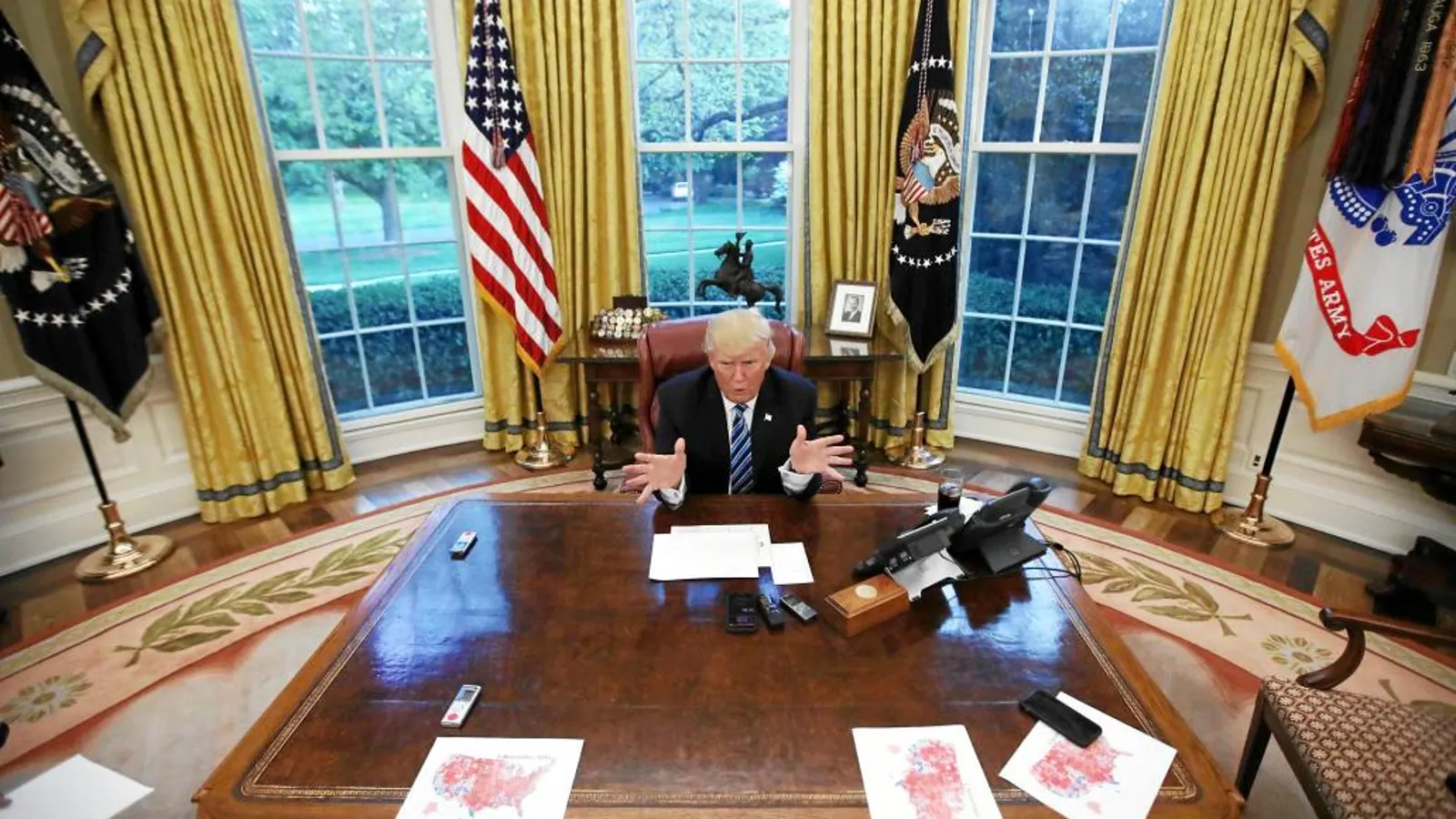 El presidente Donald Trump, sentado ante su mesa en el Despacho Oval