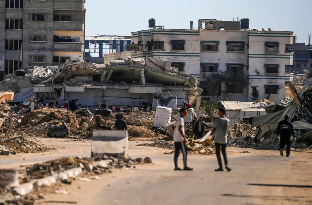 Palestinos caminan por una calle durante una operación militar israelí en el campo de refugiados de Al Bureij, en el centro de la Franja de Gaza. EFE/EPA/Mohammed Saber