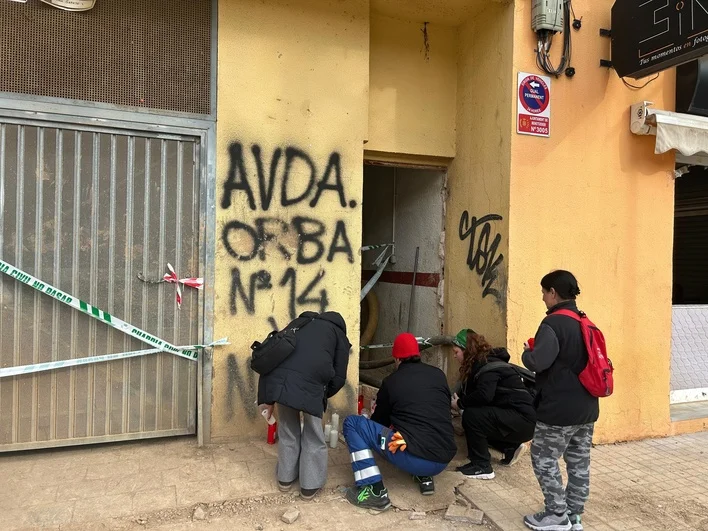 Varias personas colocan velas ante el edificio en el que falleció un trabajador por el derrumbe en Benetússer. B. H.