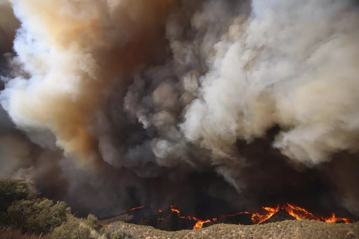 Columnas de humo se alzan mientras el incendio Hughes arde en Castaic, California, el miércoles 22 de enero de 2025. (Ethan Swope / Associated Press)